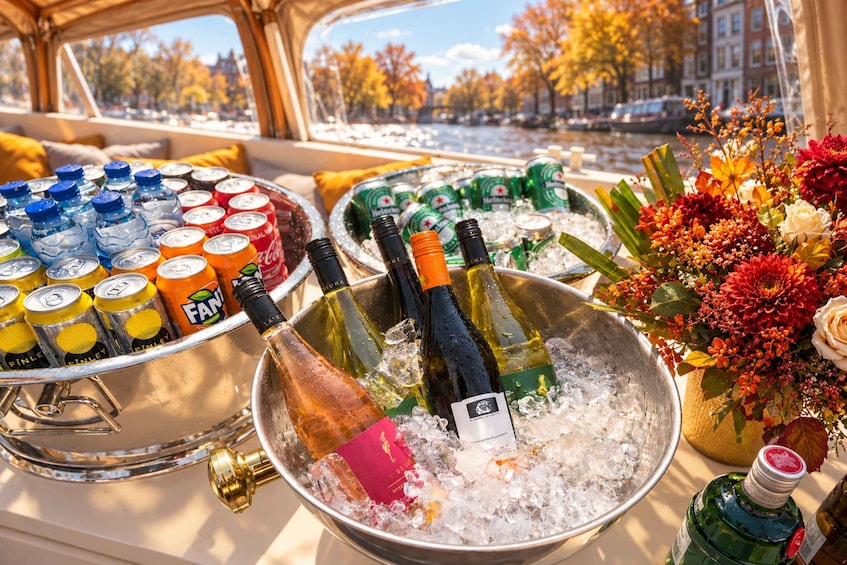 A boat with a variety of beverages in ice buckets, a bouquet of flowers, and a view of a cityscape with autumn trees. 5