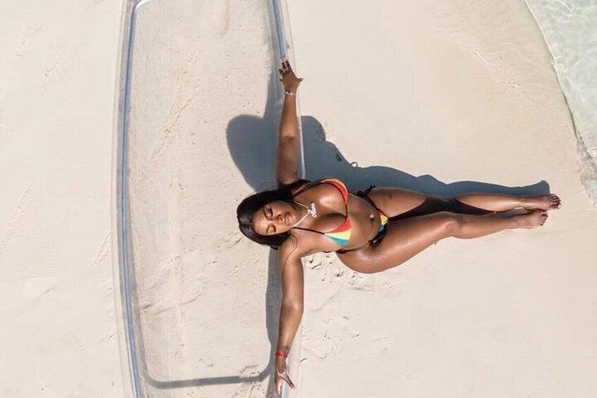 A person lying on a sandy beach with a clear sky above. 5