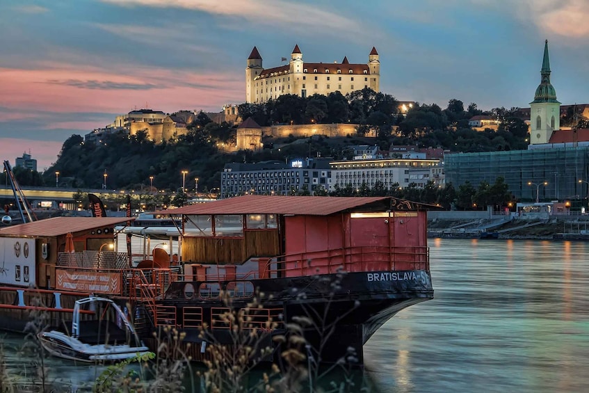 A historic castle on a hill, a church spire, and a boat named Bratislava. 1