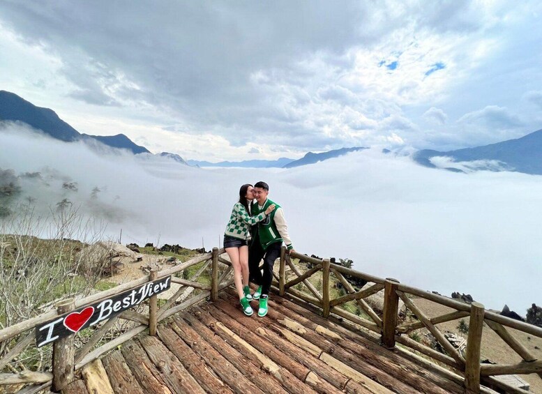 A couple embracing on a wooden viewing platform with a sign that reads 'I ♥ Best View.' 4