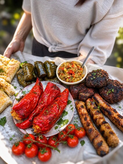 A variety of grilled foods including stuffed peppers, kebabs, and a bowl of salad. 1