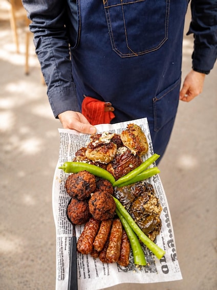 A person holding a newspaper with food items on it. 4