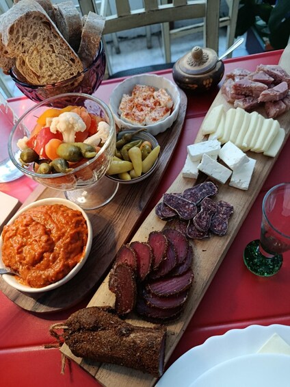 A charcuterie board with various meats, cheeses, and pickles. 2