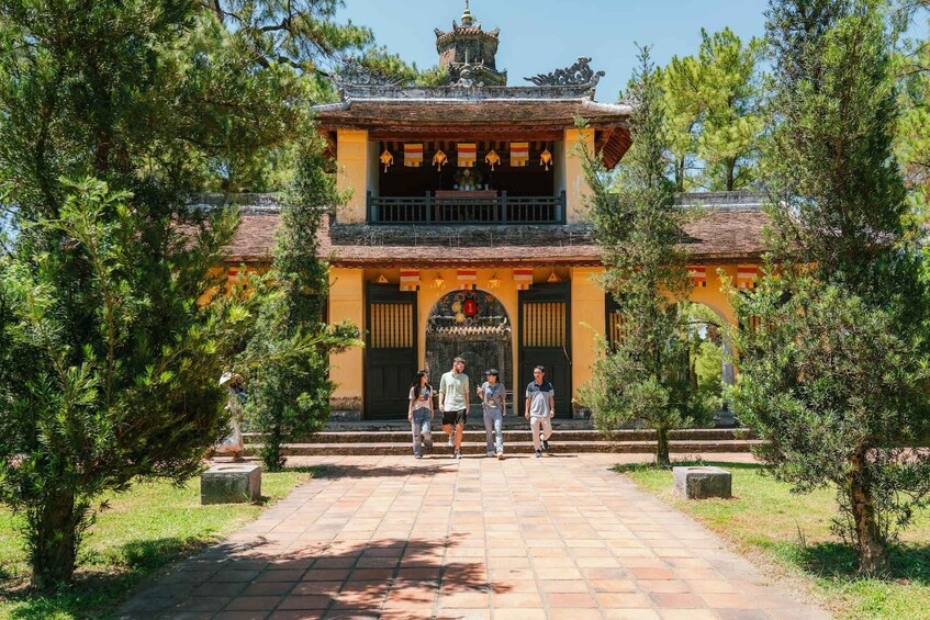 A traditional building with a tiled entrance, surrounded by trees and a clear sky. 4