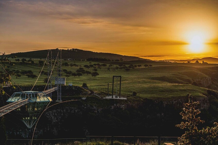 A suspension bridge, a grassy field, and a sunset over rolling hills. 3