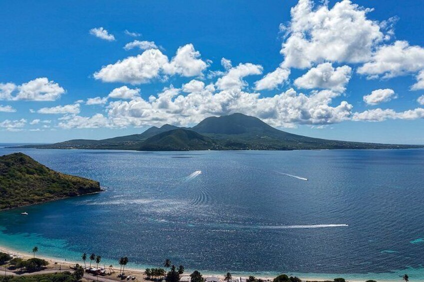 A coastal landscape with a mountain, clear blue sky, and calm sea. 3