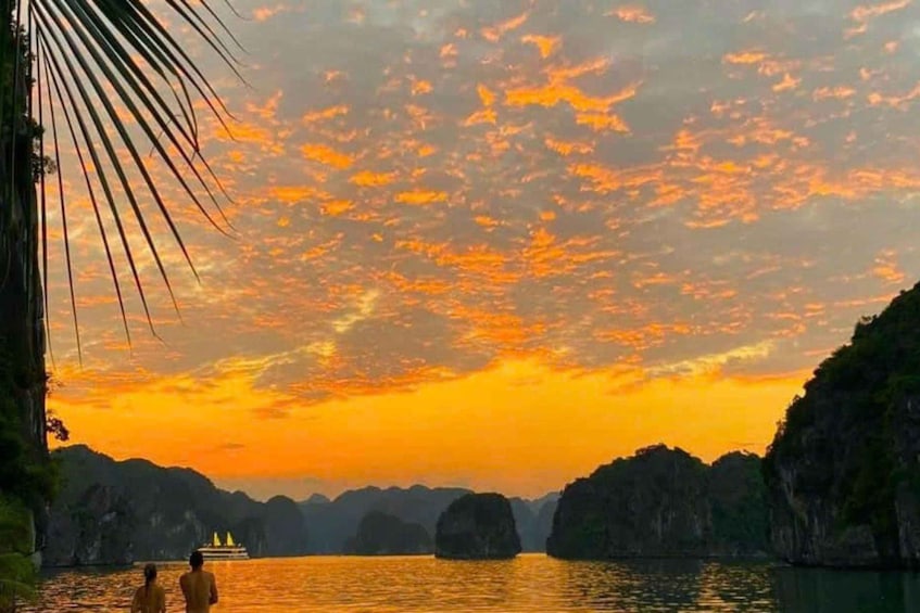 A sunset over a body of water with rock formations and a boat. 1