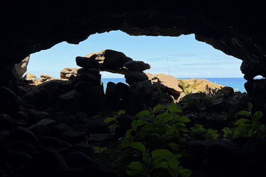 A cave opening with a view of the ocean and rocky landscape. 3
