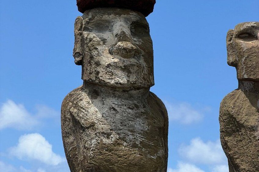 Two large stone statues with faces, set against a clear blue sky. 5