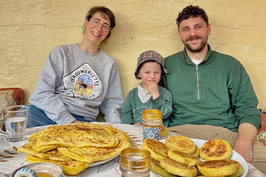 Eine Familie sitzt an einem Tisch mit Pfannkuchen und einer Sirupflasche. 1
