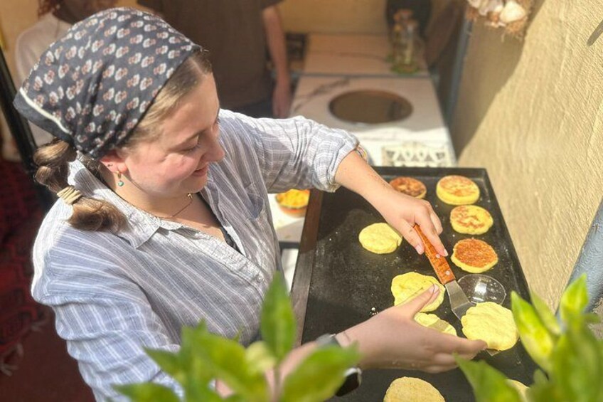 Una persona cocinando en una parrilla con tortillas y salsa roja. 3