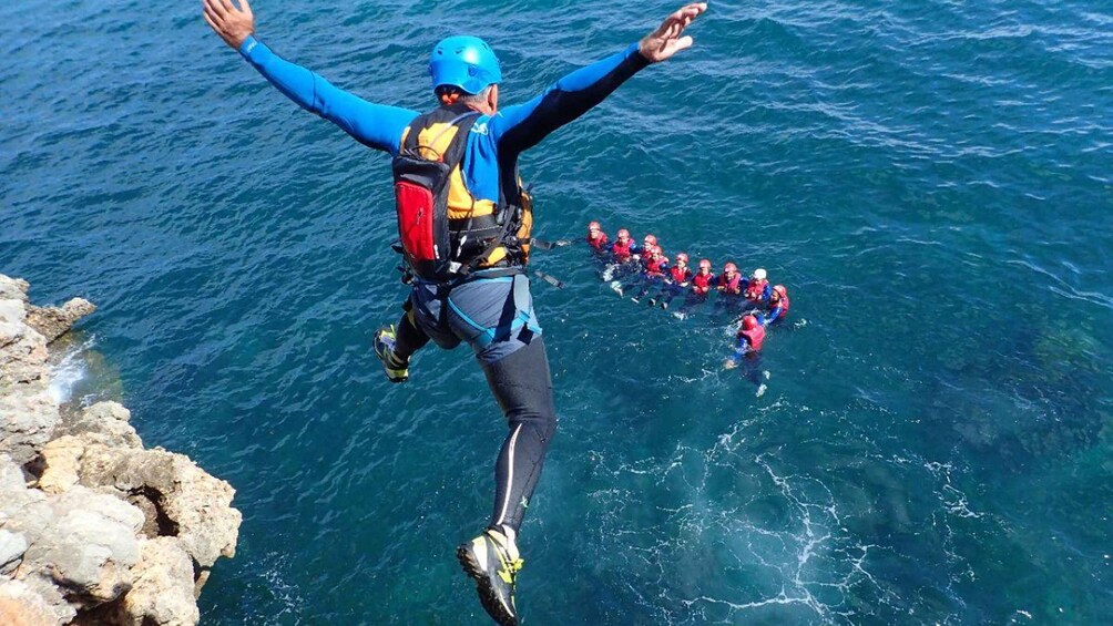 A person skydiving with a group of divers below. 5