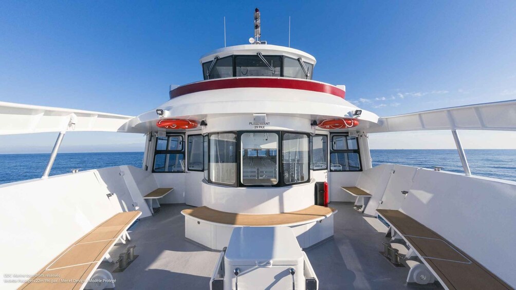 A boat deck with seating and a control tower. 3