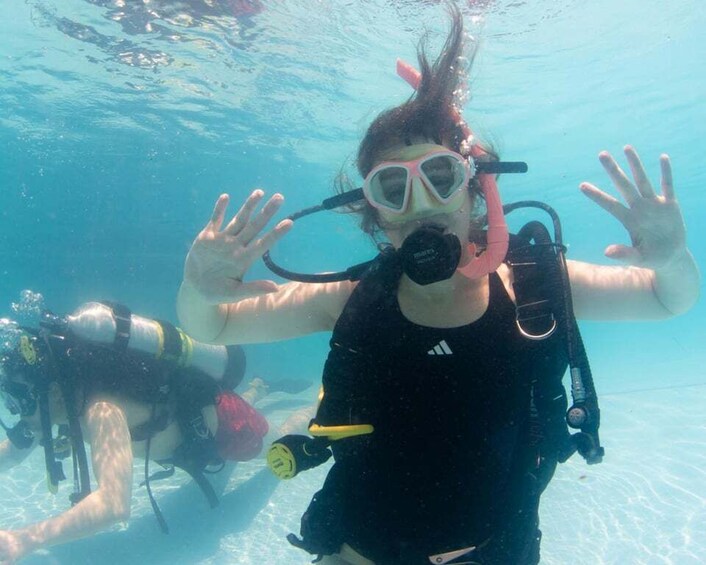 En person under vandet med snorkel og finner, omgivet af krystalklart, blåt vand. 2