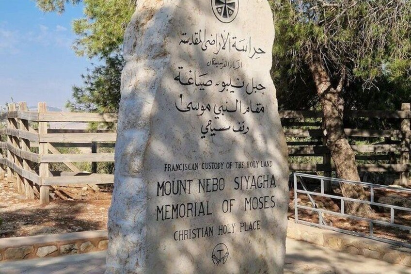 Ett stenmonument med inskriptioner på flera språk, inklusive engelska, arabiska och syriaka, vid berget Nebo. 3