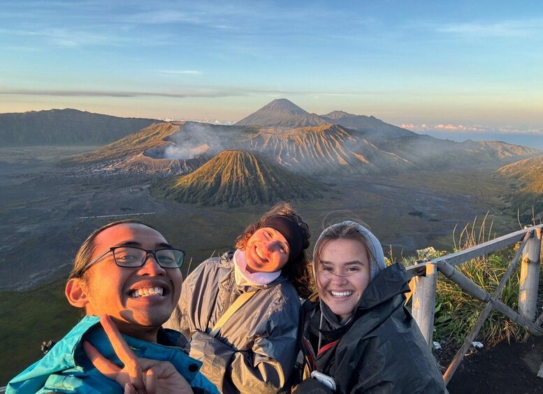 Three people taking a selfie with a mountain range in the background. 3