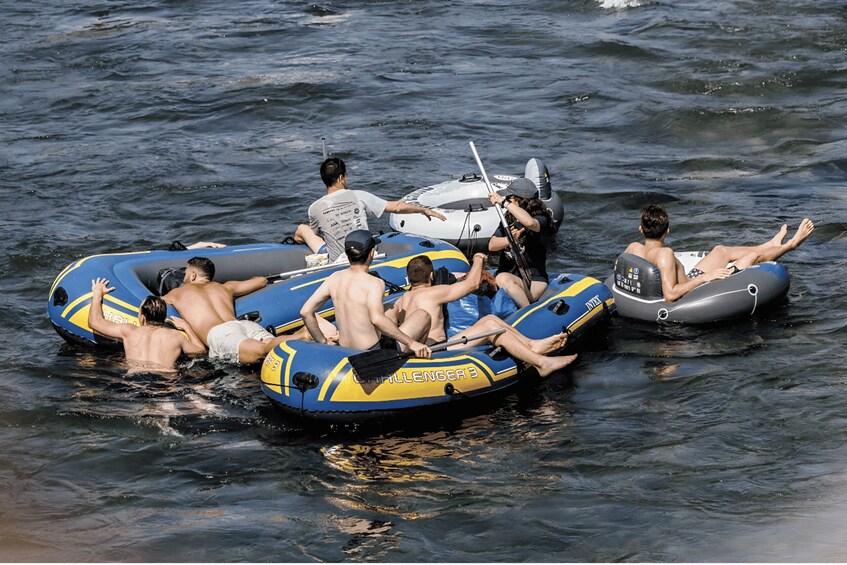 People floating on blue and gray inflatable rafts on a body of water. 2