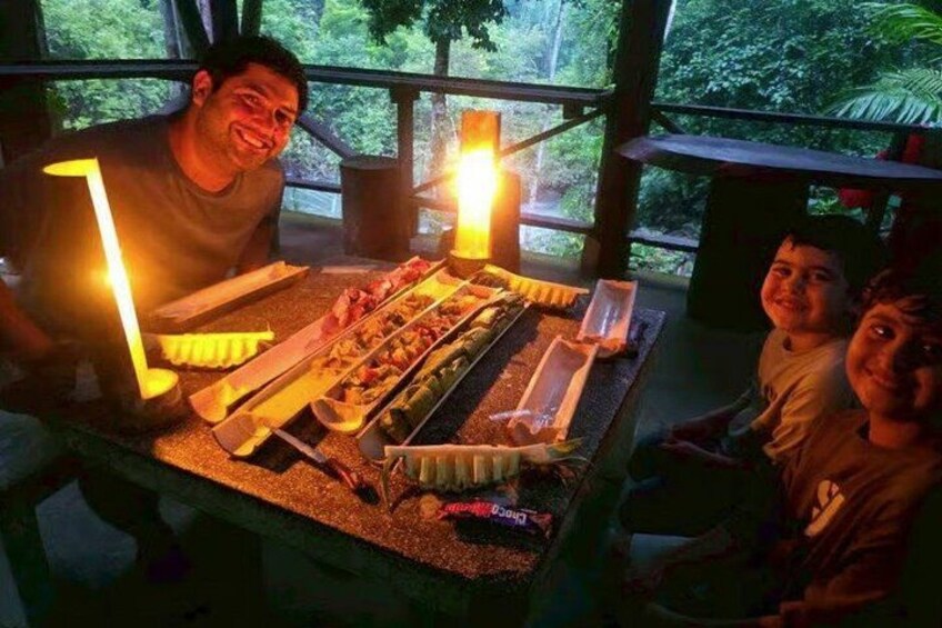 Iemand zit aan een tafel met verschillende soorten eten en kaarsen. 5