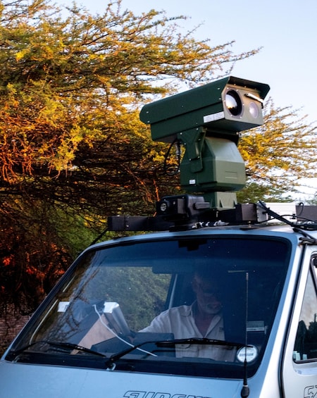 A vehicle with a mounted surveillance camera on the roof. 3