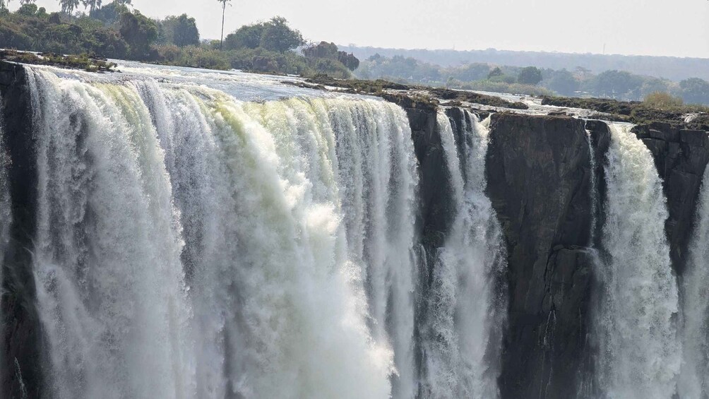 A large waterfall cascading over a rocky cliff. 1