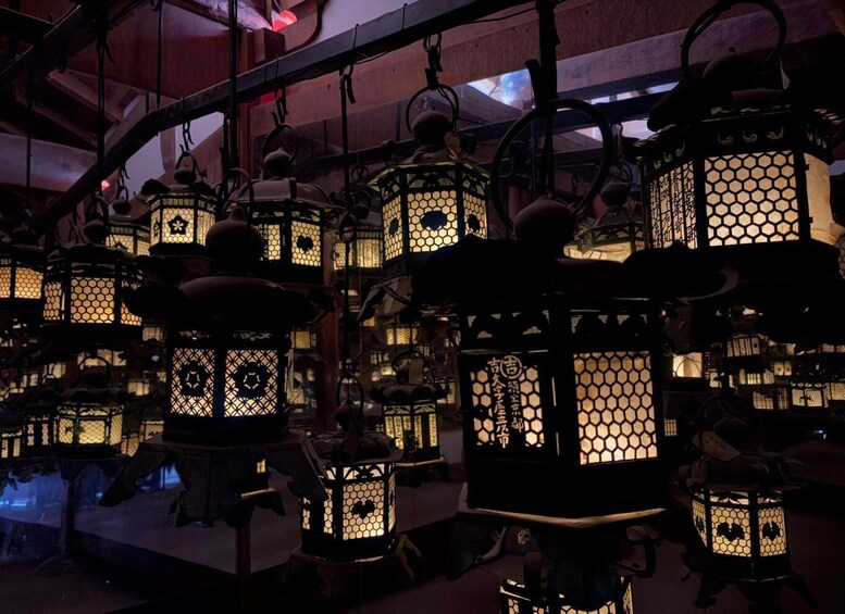 A collection of traditional lanterns with intricate designs and hanging from a ceiling. 2