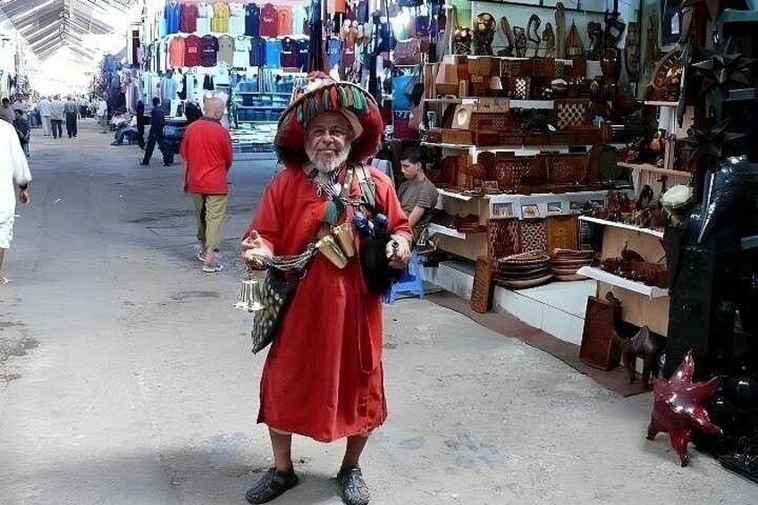A market with various stalls selling bags and shoes. 5