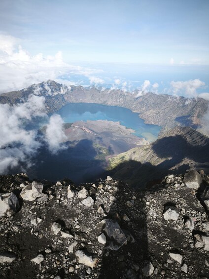A mountainous landscape with a lake surrounded by peaks and clouds. 5