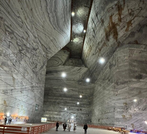 A large, cavernous interior with high ceilings and a polished stone wall. 1