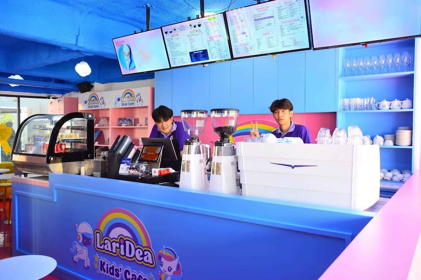 A brightly colored kiosk with a rainbow logo, a menu board, and a coffee machine. 5