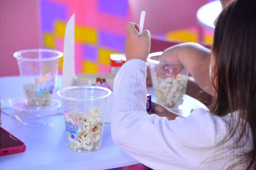 A person sitting at a table with popcorn and a phone. 2