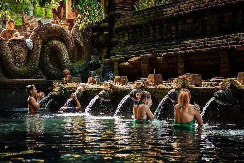 Una fuente de agua con múltiples cascadas, una estructura de piedra y una gran escultura de dragón. 4
