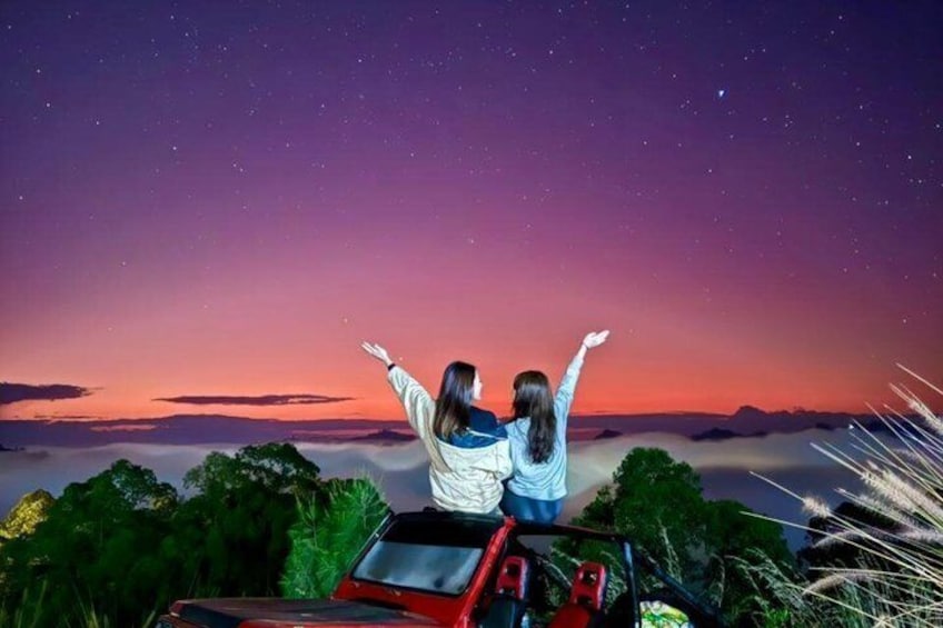Due persone su un veicolo con un cielo stellato sullo sfondo. 1