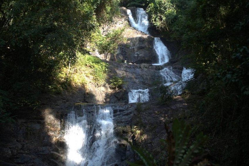 A multi-tiered waterfall surrounded by dense forest. 5