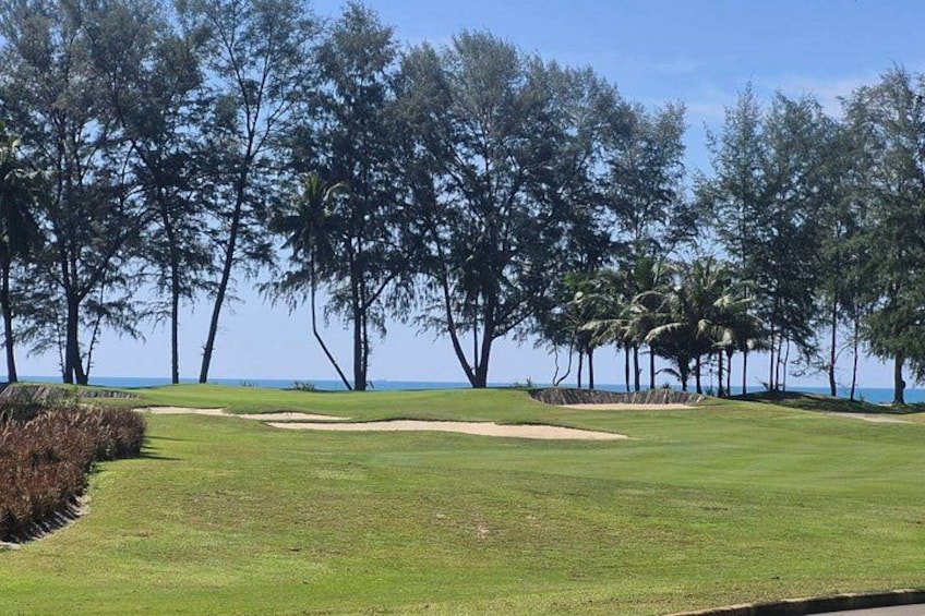 A golf course with sand bunkers and trees. 2