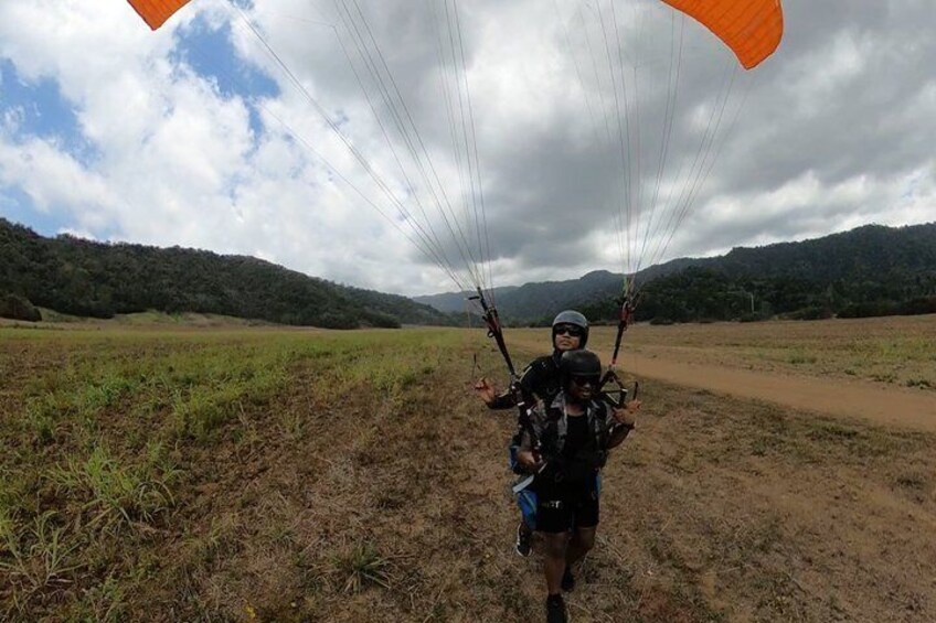Een persoon paraglidet met een parachute boven een landelijk gebied. 3