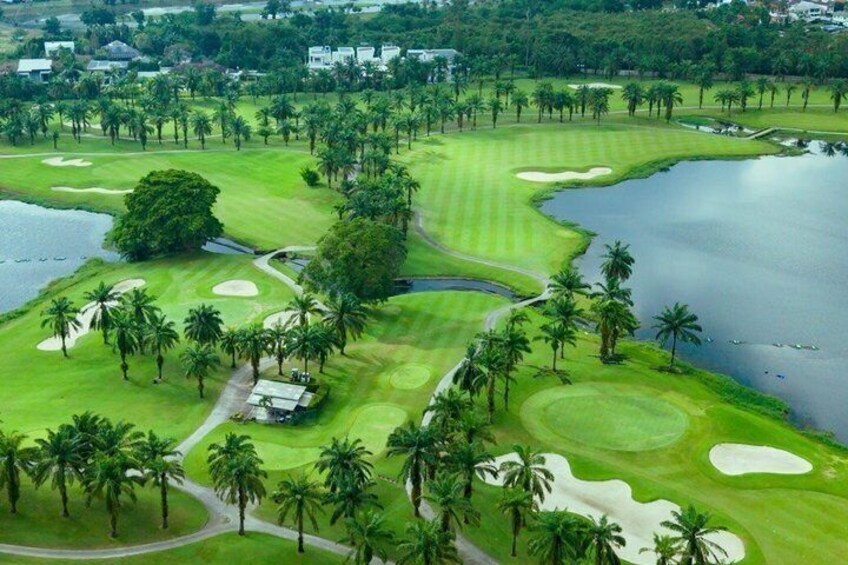 A golf course with water hazards, sand bunkers, and palm trees. 1