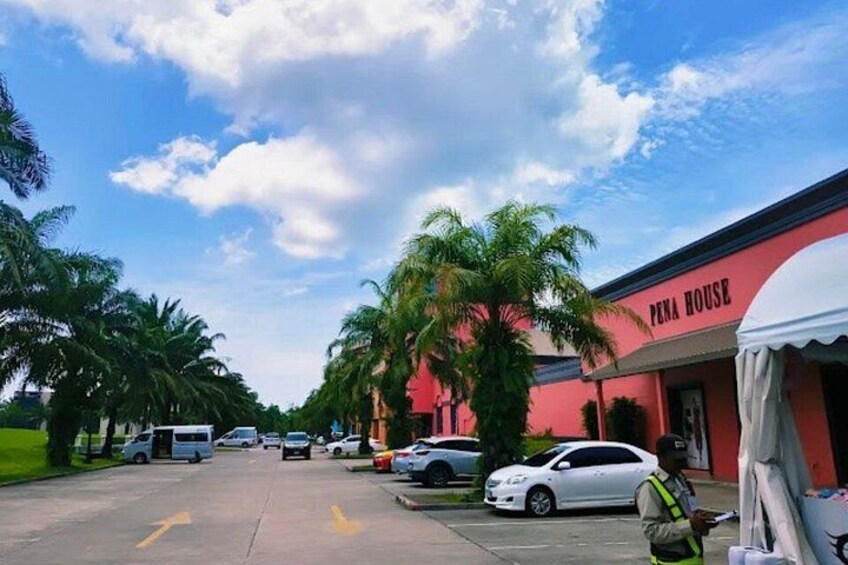 A street with parked cars, a building labeled 'PENA HOUSE,' and palm trees. 2