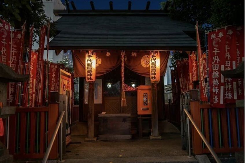 A traditional Japanese shrine entrance with red banners and lanterns. 5
