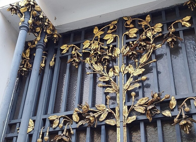 A building facade with ornate gold leaf decorations and blue columns. 3