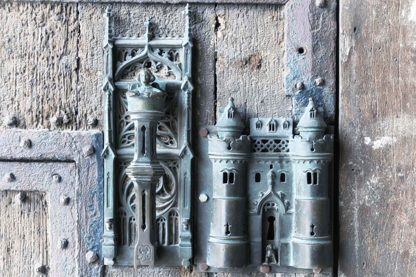 A detailed metal sculpture of a castle with intricate designs and a figure on top. 4