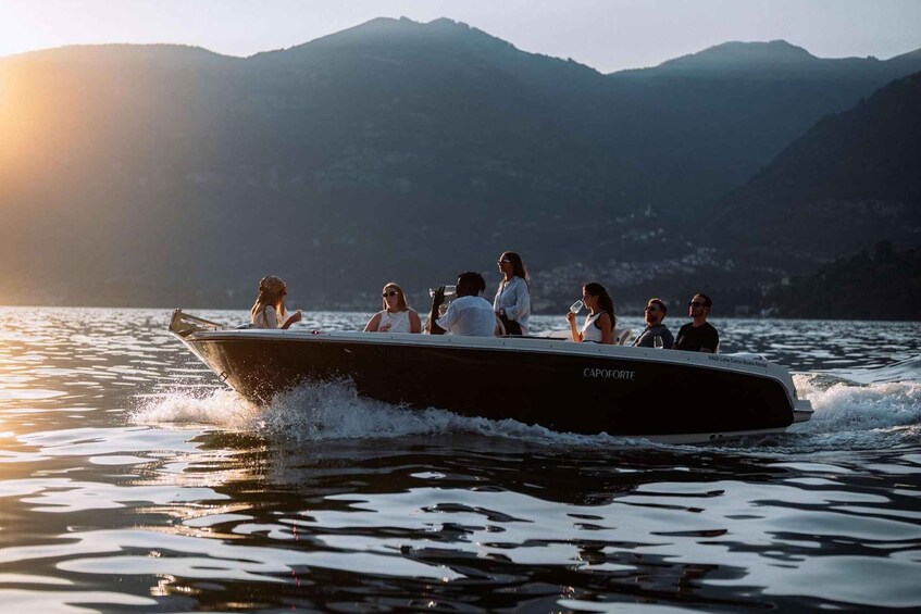 A boat with passengers on a lake with mountains in the background. 1