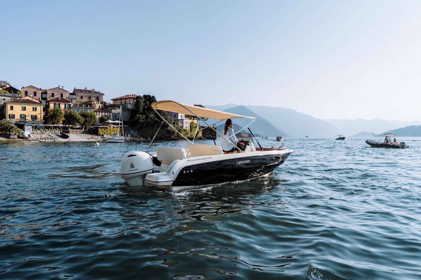 A boat on calm water with houses and mountains in the background. 4