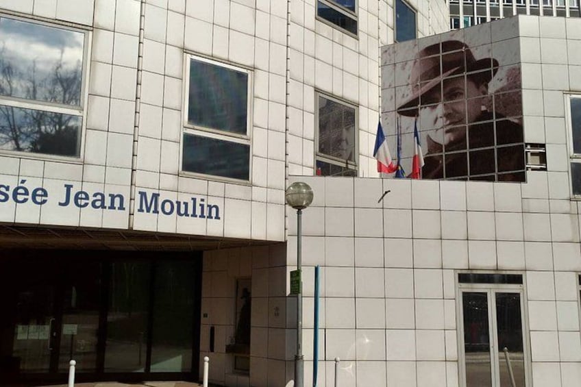 Un bâtiment à la façade recouverte de carreaux, avec une grande fenêtre et une enseigne portant l’inscription « Sève Jean Moulin ». 3