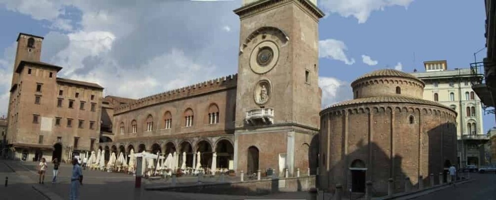 A historic building with a clock tower, arched walkways, and a dome. 5