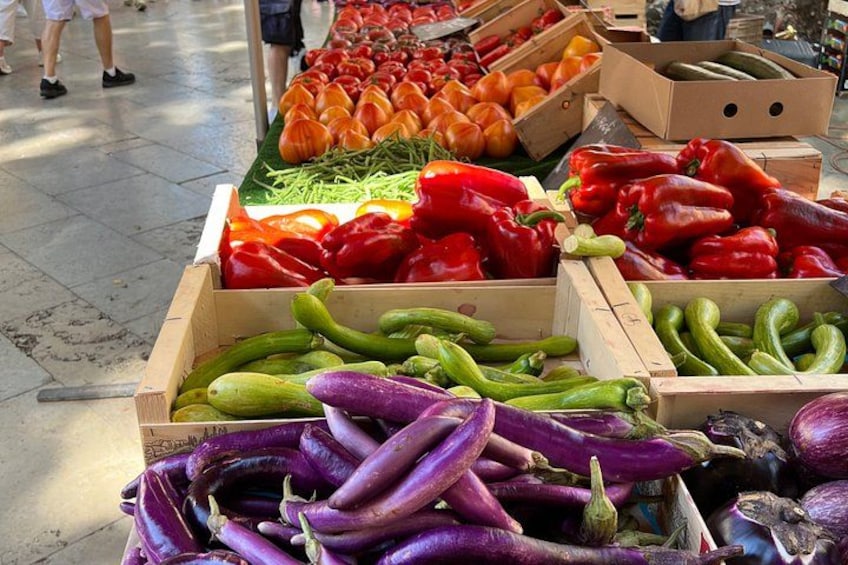 En marknad med ett varierat utbud av grönsaker, som till exempel paprika, tomater och aubergine. 2