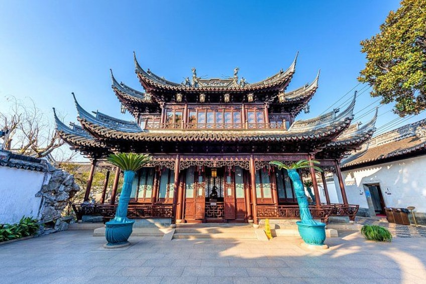 Un bâtiment traditionnel chinois, caractérisé par une architecture riche et élaborée, notamment des toits incurvés et des sculptures sur bois complexes. 1