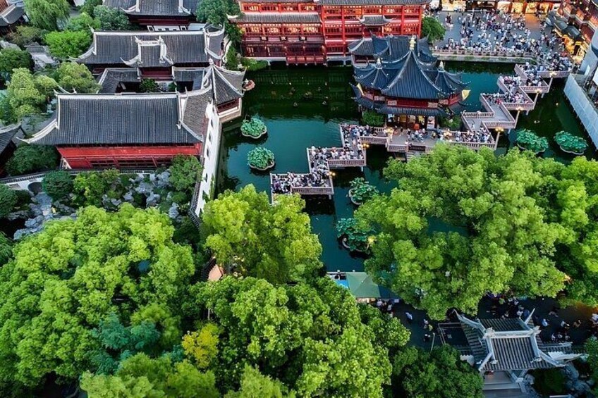 Un jardin intérieur chinois traditionnel, agrémenté de bâtiments, d’éléments d’eau et d’une végétation luxuriante. 4