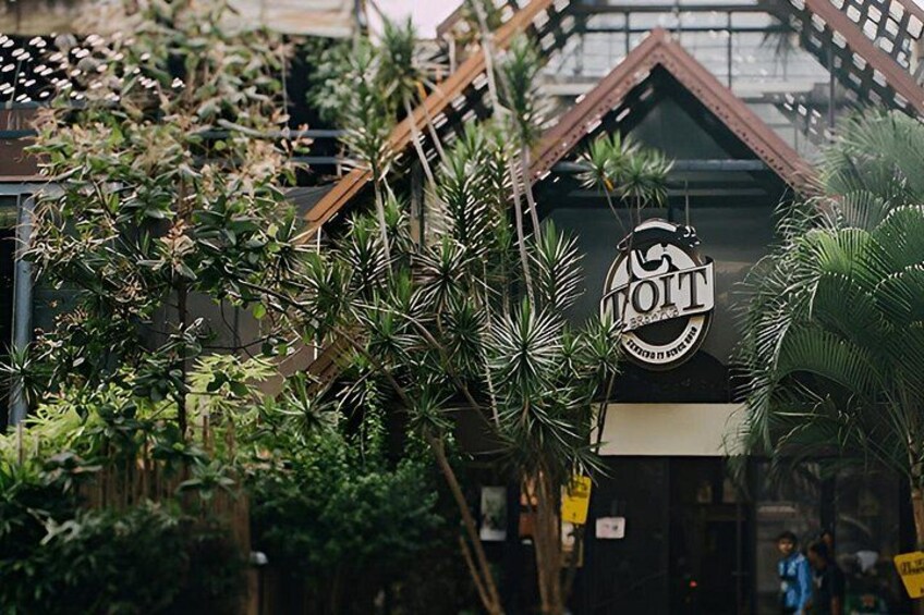 A building with a sign that reads 'WOT' surrounded by lush greenery. 3