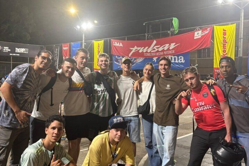 A group of people posing for a photo at an event with banners and flags in the background. 1