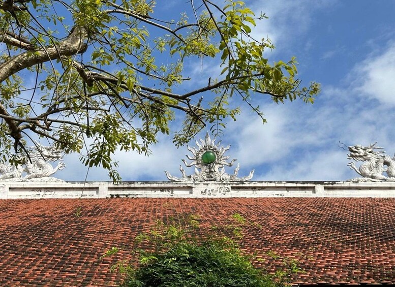 A traditional temple roof with ornate dragon sculptures and a clear blue sky. 2